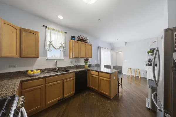 a kitchen with stainless steel appliances granite countertop a sink stove and refrigerator