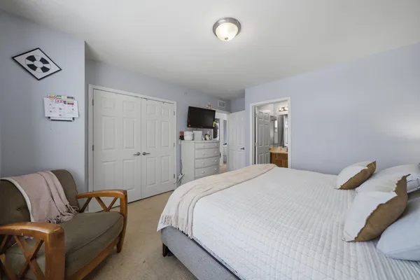 a bedroom with a bed couch and a window