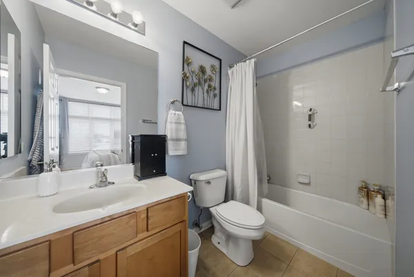 a bathroom with a toilet a sink a mirror a bathtub and vanity