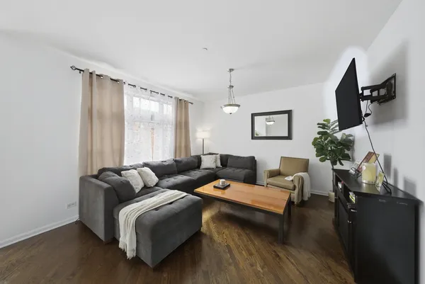 a living room with furniture wooden floor and a flat screen tv