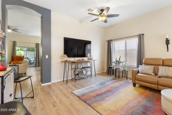 a living room with furniture and a flat screen tv with wooden floor