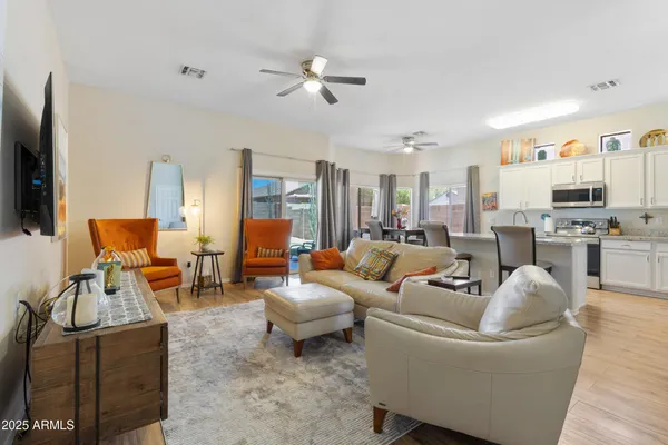 a living room with furniture kitchen view and a flat screen tv
