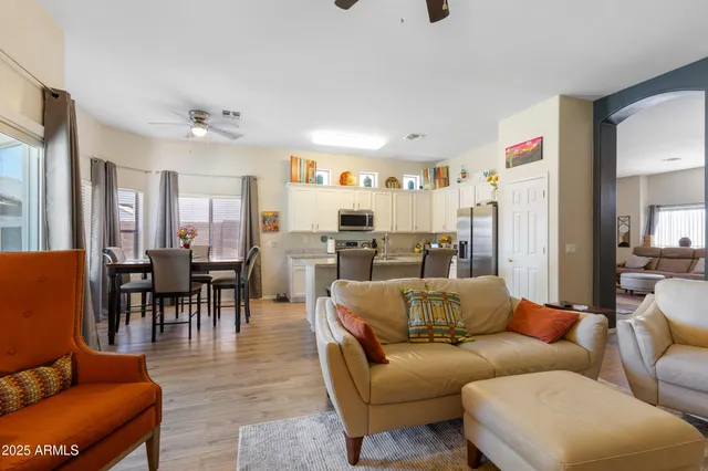 a living room with furniture wooden floor and a kitchen view