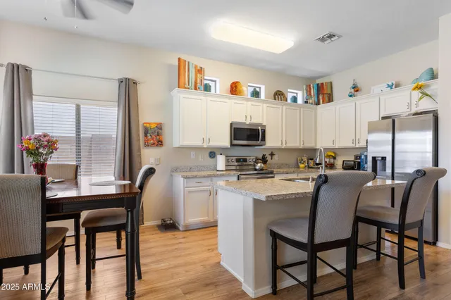 a kitchen with granite countertop a refrigerator and a stove top oven