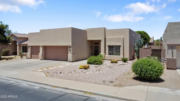 a front view of a house with garden and plants