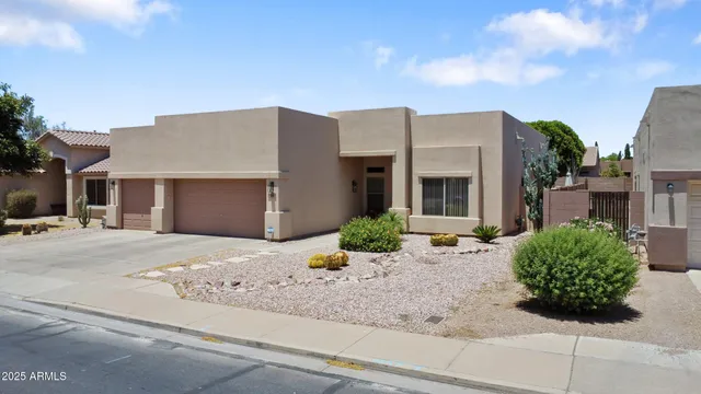 a front view of a house with garden and plants