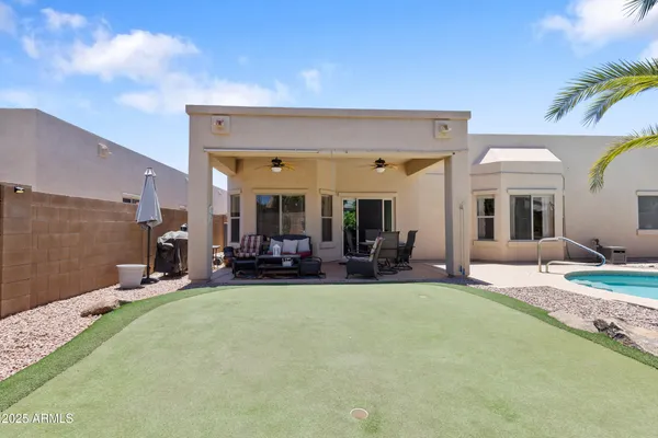 a view of a swimming pool with a yard and palm trees