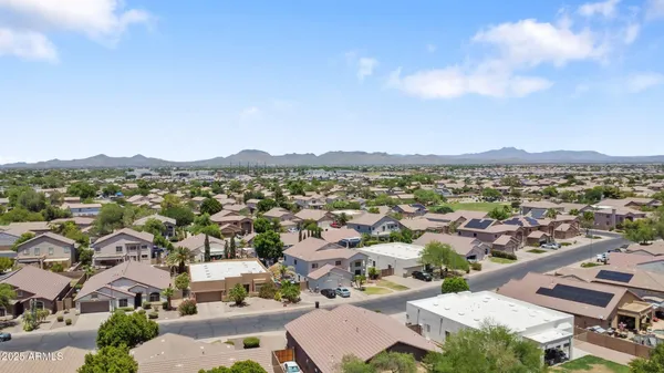 an aerial view of residential houses with outdoor space and trees