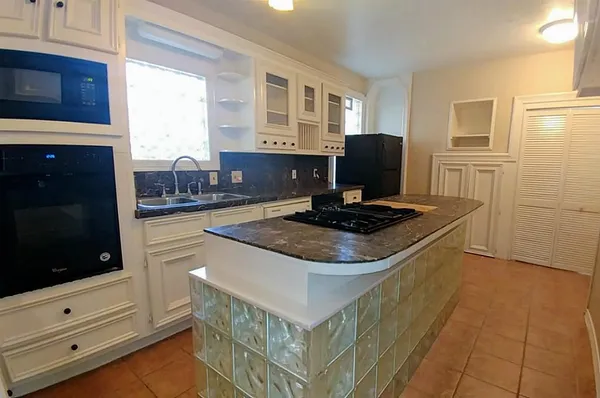 a kitchen with stainless steel appliances granite countertop a stove and a microwave