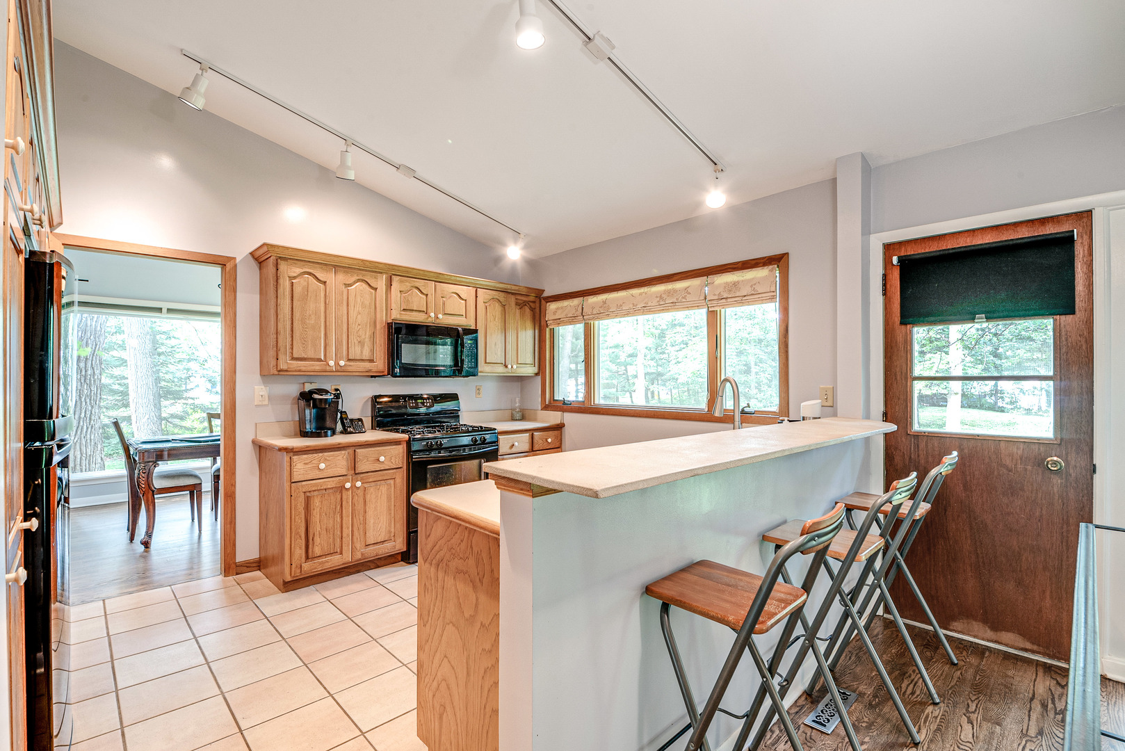 703 Hickory Road Woodstock, IL 60098 - Photo 14 of 33 a kitchen with stainless steel appliances granite countertop a stove top oven a sink dishwasher a dining table and chairs with wooden floor