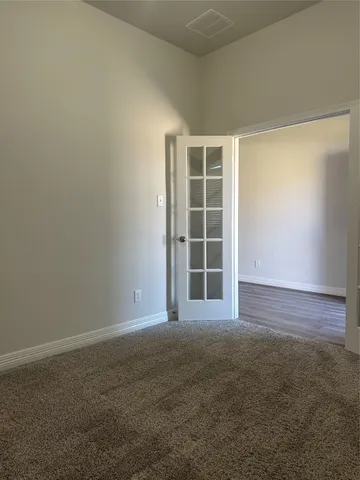 an empty room with windows and cabinet