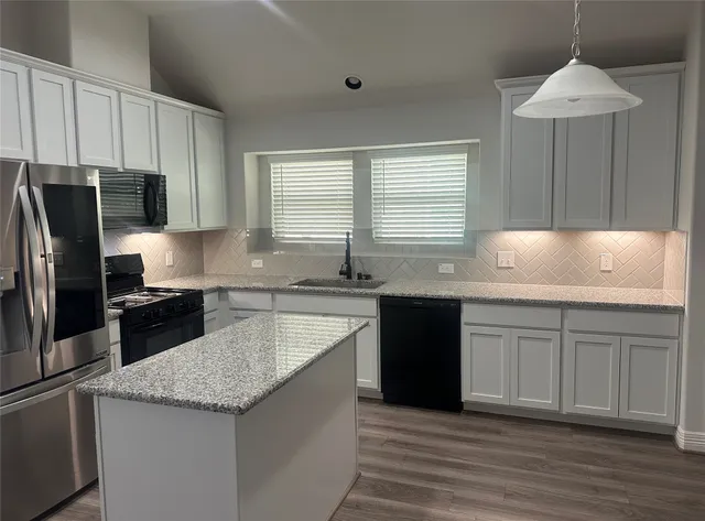 a metallic refrigerator freezer sitting in a kitchen