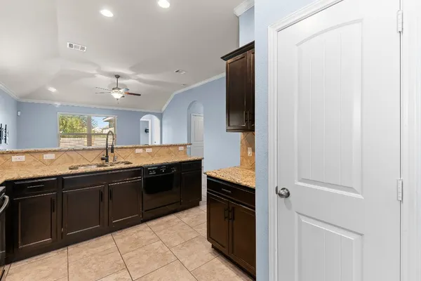 a kitchen with a sink granite counter tops and a window