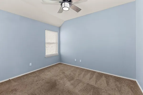 an empty room with a window and a fan