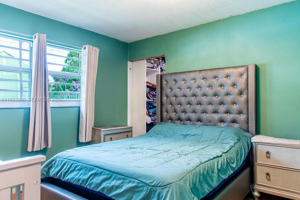 11751 Northwest 32nd Manor Sunrise, FL 33323 - Photo 19 of 32 a bed sitting in a bedroom next to a window
