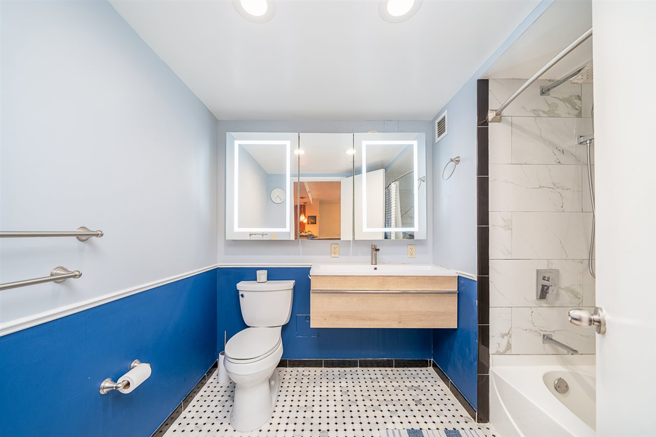 700 Grove Street, Unit 4V Jersey City, NJ 07310 - Photo 14 of 25 a bathroom with a toilet a sink and bathtub