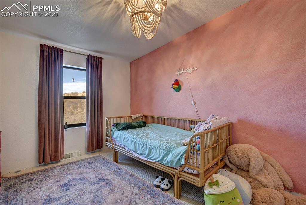 21050 McDaniels Road Calhan, CO 80808 - Photo 29 of 46 a bedroom with a bed and wooden floor