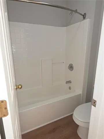 a bath room with a toilet and a bath tub