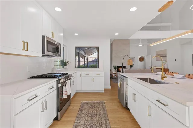 a view of a kitchen counter top a sink and chandelier