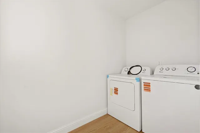 a view of a hallway with wooden floor and a living room