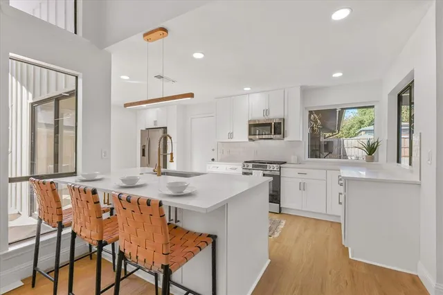 a kitchen with white cabinets sink and stainless steel appliances