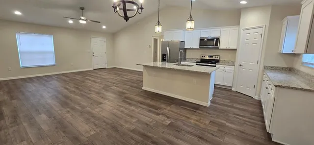 a kitchen with stainless steel appliances granite countertop a stove a sink and a refrigerator