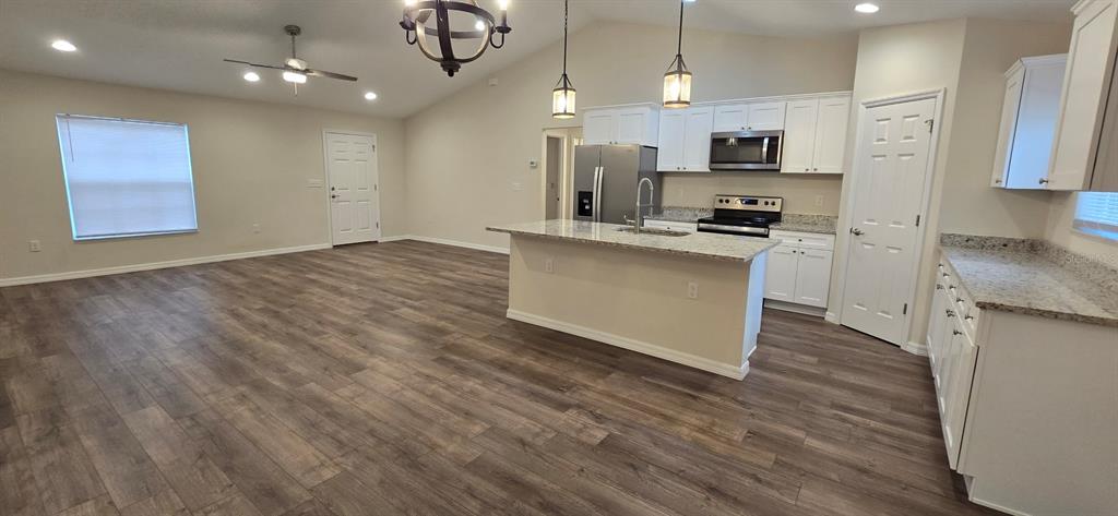 16263 Southwest 48th Circle Ocala, FL 34473 - Photo 5 of 16 a kitchen with stainless steel appliances granite countertop a stove a sink and a refrigerator