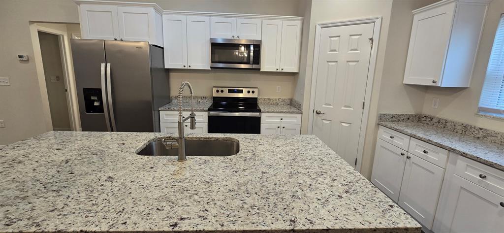 16263 Southwest 48th Circle Ocala, FL 34473 - Photo 6 of 16 a kitchen with stainless steel appliances granite countertop a refrigerator a stove top oven a sink and dishwasher