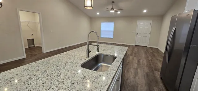 a kitchen with granite countertop a sink and a refrigerator