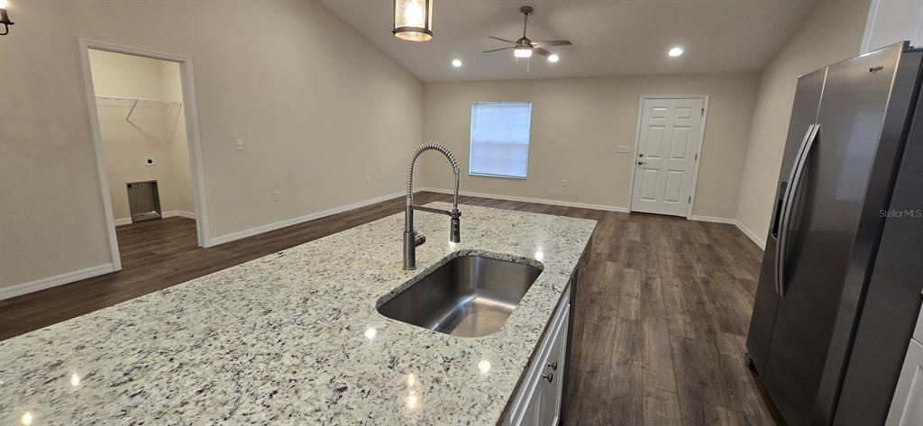 16263 Southwest 48th Circle Ocala, FL 34473 - Photo 7 of 16 a kitchen with granite countertop a sink and a refrigerator