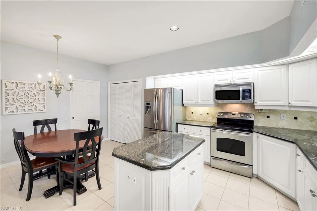 11822 Quail Village Way Naples, FL 34119 - Photo 11 of 34 a kitchen with a stove a sink and a refrigerator
