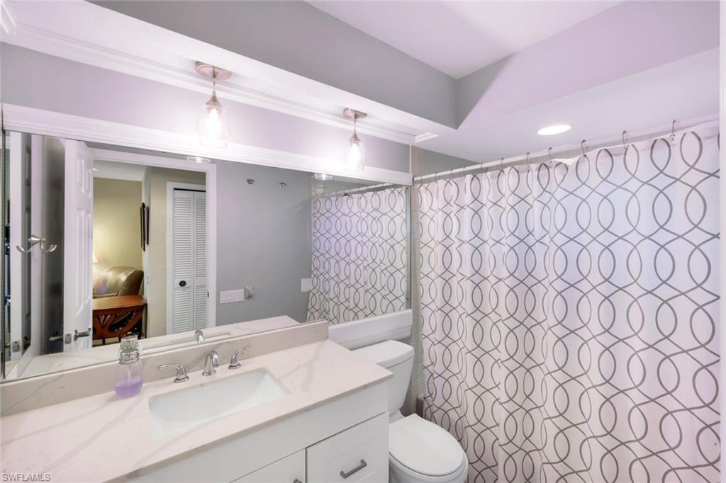 11822 Quail Village Way Naples, FL 34119 - Photo 19 of 34 a bathroom with a sink a toilet and shower curtain