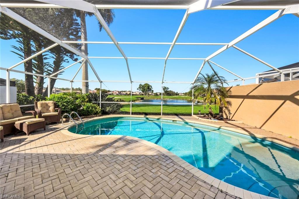 11822 Quail Village Way Naples, FL 34119 - Photo 2 of 34 a view of swimming pool with seating area and small yard in the back