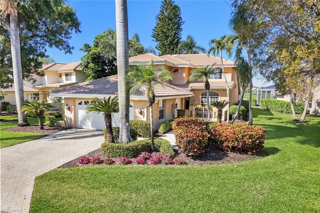 11822 Quail Village Way Naples, FL 34119 - Photo 21 of 34 a view of a house with a garden and pathway