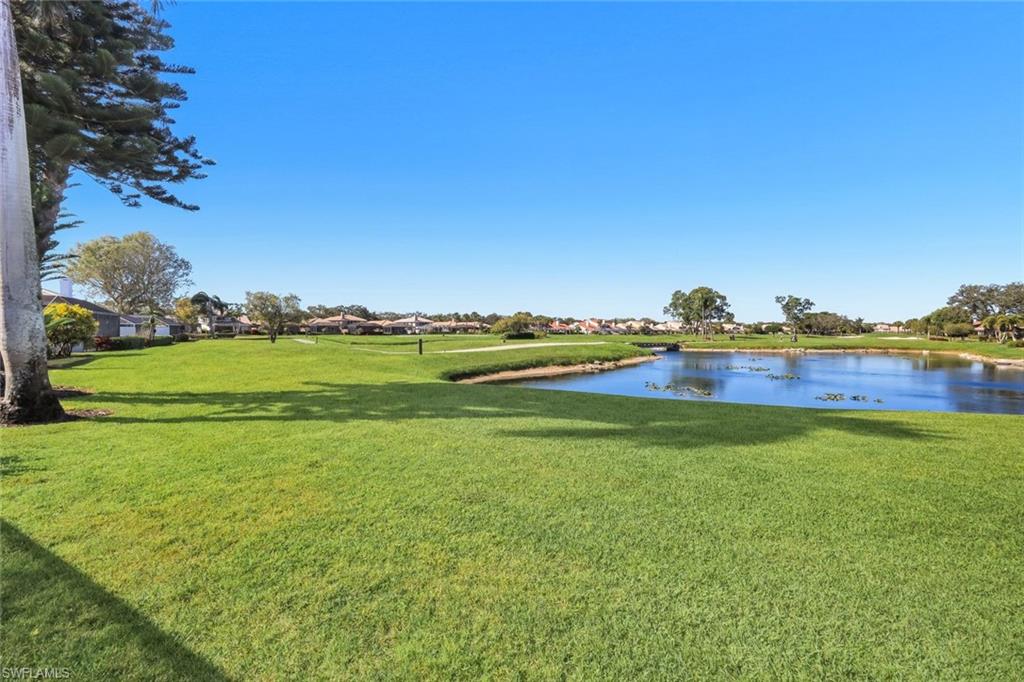 11822 Quail Village Way Naples, FL 34119 - Photo 23 of 34 a view of a lake with houses in the back