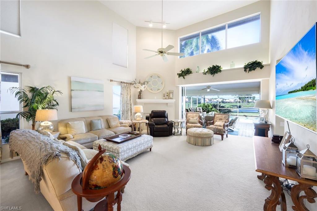 11822 Quail Village Way Naples, FL 34119 - Photo 7 of 34 a living room with furniture fireplace and a large window