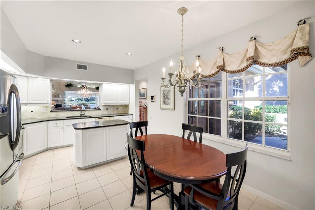 11822 Quail Village Way Naples, FL 34119 - Photo 10 of 34 a dining room filled chandelier and kitchen view