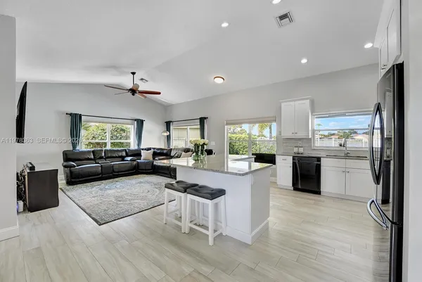 a living room with furniture and kitchen view