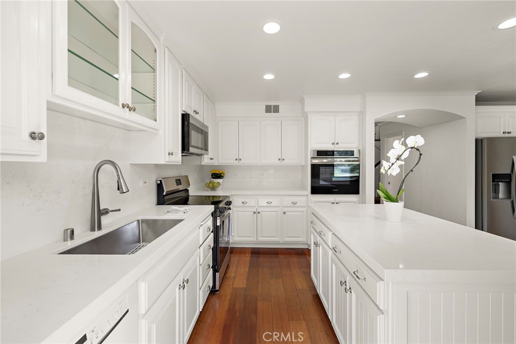 5 Morningside Irvine, CA 92603 - Photo 11 of 58 a kitchen with granite countertop a sink a counter top space stainless steel appliances and cabinets