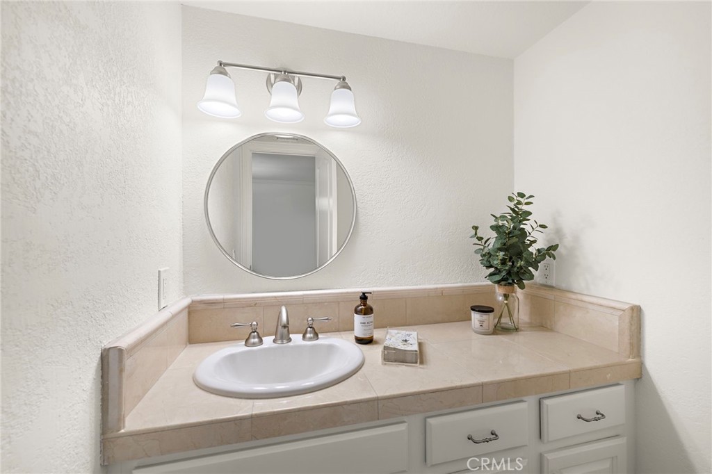 5 Morningside Irvine, CA 92603 - Photo 32 of 58 a bathroom with a granite countertop sink and a mirror