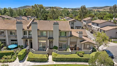 an aerial view of a residential houses with yard