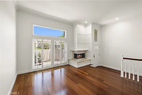 a view of a room with wooden floor and white walls