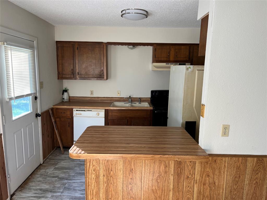 3711 Greenwood Road Weatherford, TX 76088 - Photo 8 of 15 a kitchen with a sink and a refrigerator