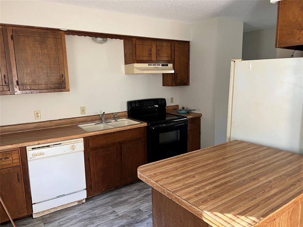 3711 Greenwood Road Weatherford, TX 76088 - Photo 9 of 15 a kitchen with a sink and a refrigerator