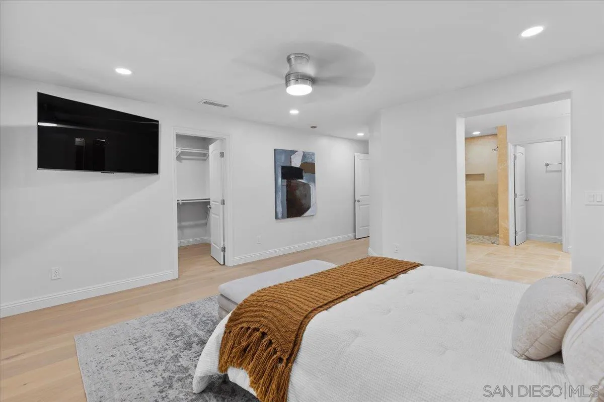 16902 Via De Santa Fe, Unit 12 Rancho Santa Fe, CA 92091 - Photo 33 of 54 a spacious bedroom with a bed and a television