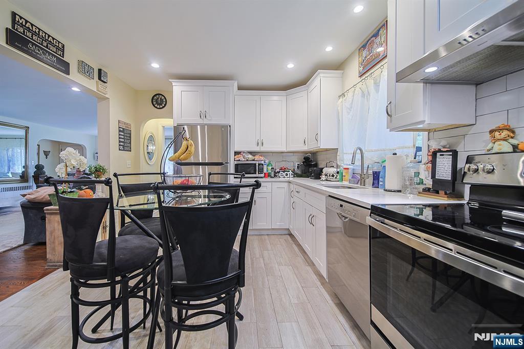 1003 Cumbermeade Road Fort Lee, NJ 07024 - Photo 9 of 23 a kitchen with a table chairs stove and cabinets