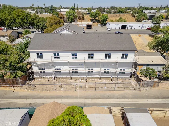 an aerial view of residential houses with outdoor space and parking