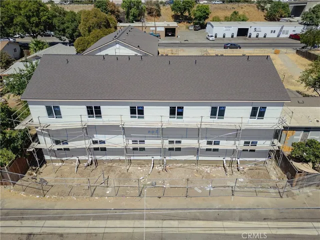an aerial view of residential houses with outdoor space and parking