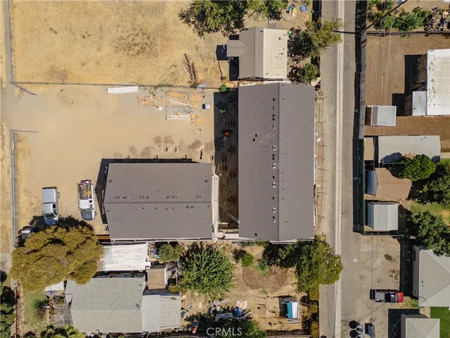 an aerial view of a house with a yard and large tree