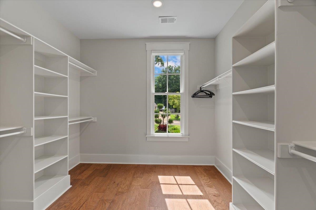240 Burrows Road Collierville, TN 38017 - Photo 17 of 37 Spacious closet featuring extensive built-in shelving, hanging rods, wood-finish flooring, a bright window, and neutral wall paint